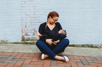 A woman nurses her baby while wearing The Multitasking Cardigan.